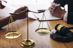 The symbolic image for court proceedings shows a scale, a hammer and two people in conversation